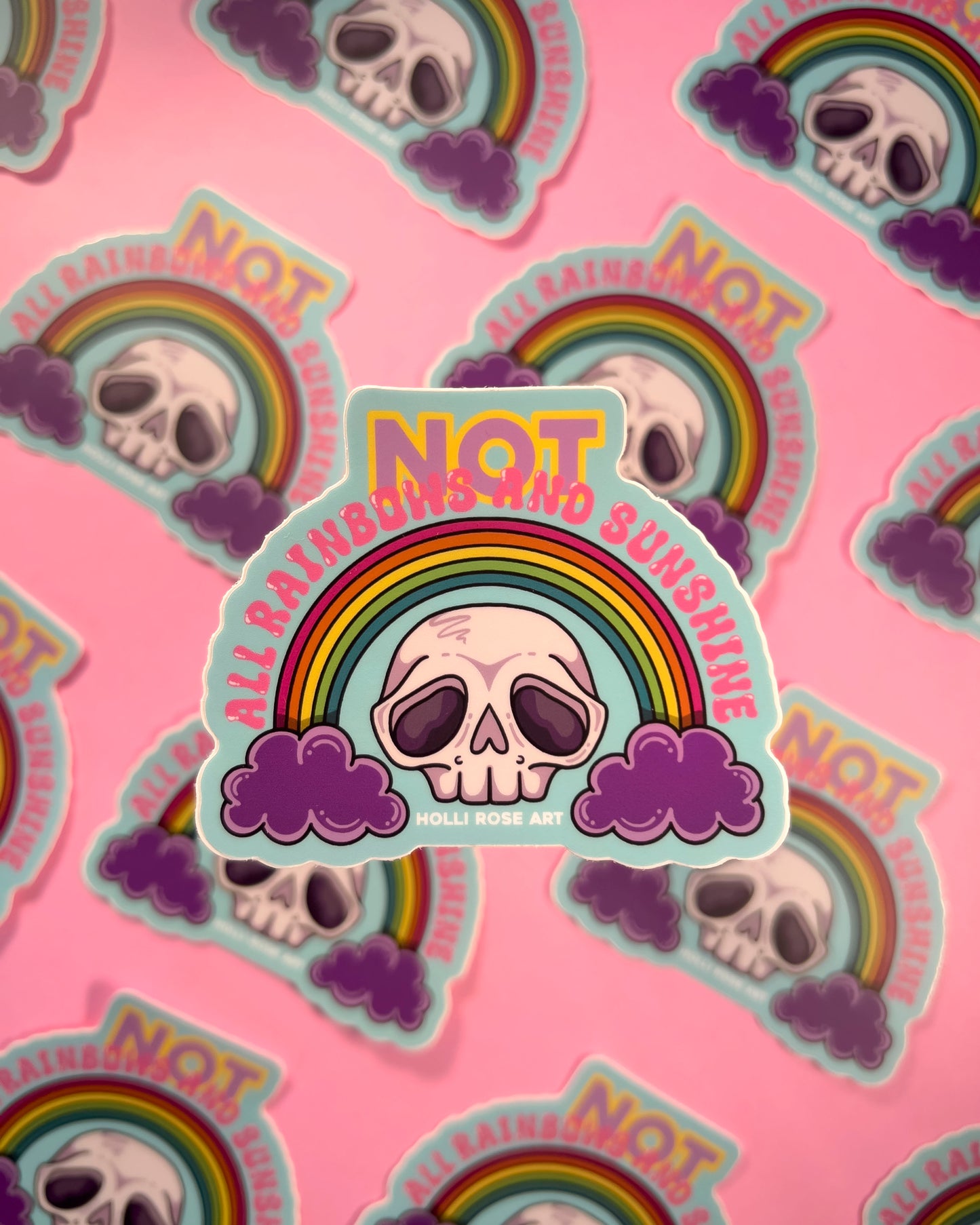 Stickers with skull design, rainbow, and 'Not All Rainbows Are Sunshine' text on a pink background.