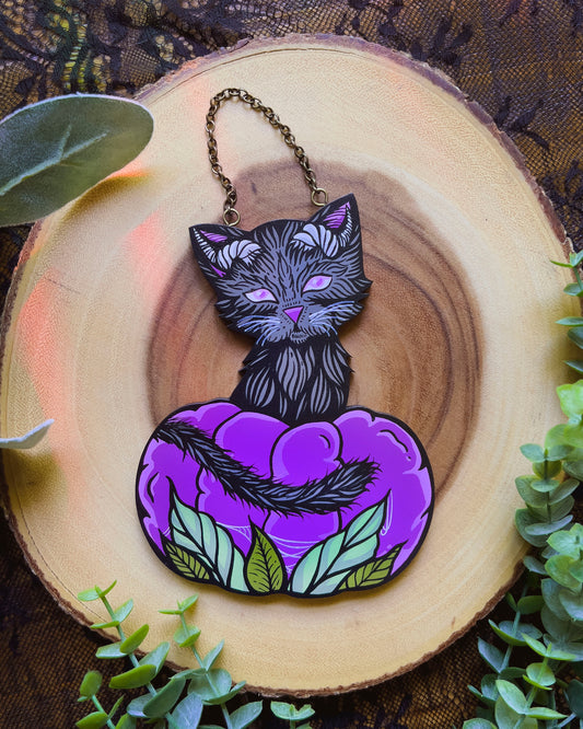 hand painted cat with horns and sitting in a purple pumpkin