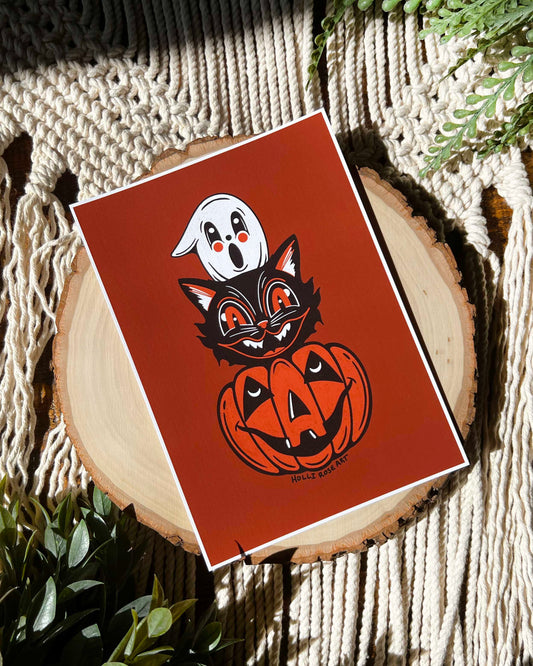 print with a pumpkin , cat head and ghost head stacked
