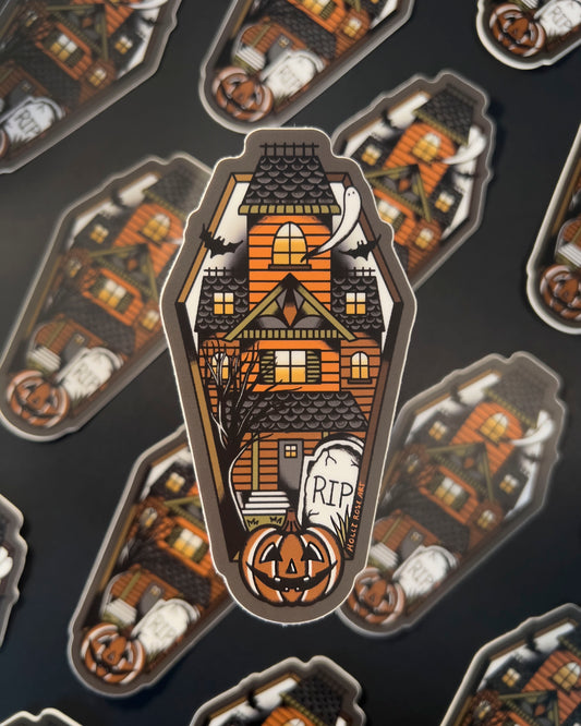 sticker shaped like a coffin with a haunted house inside
