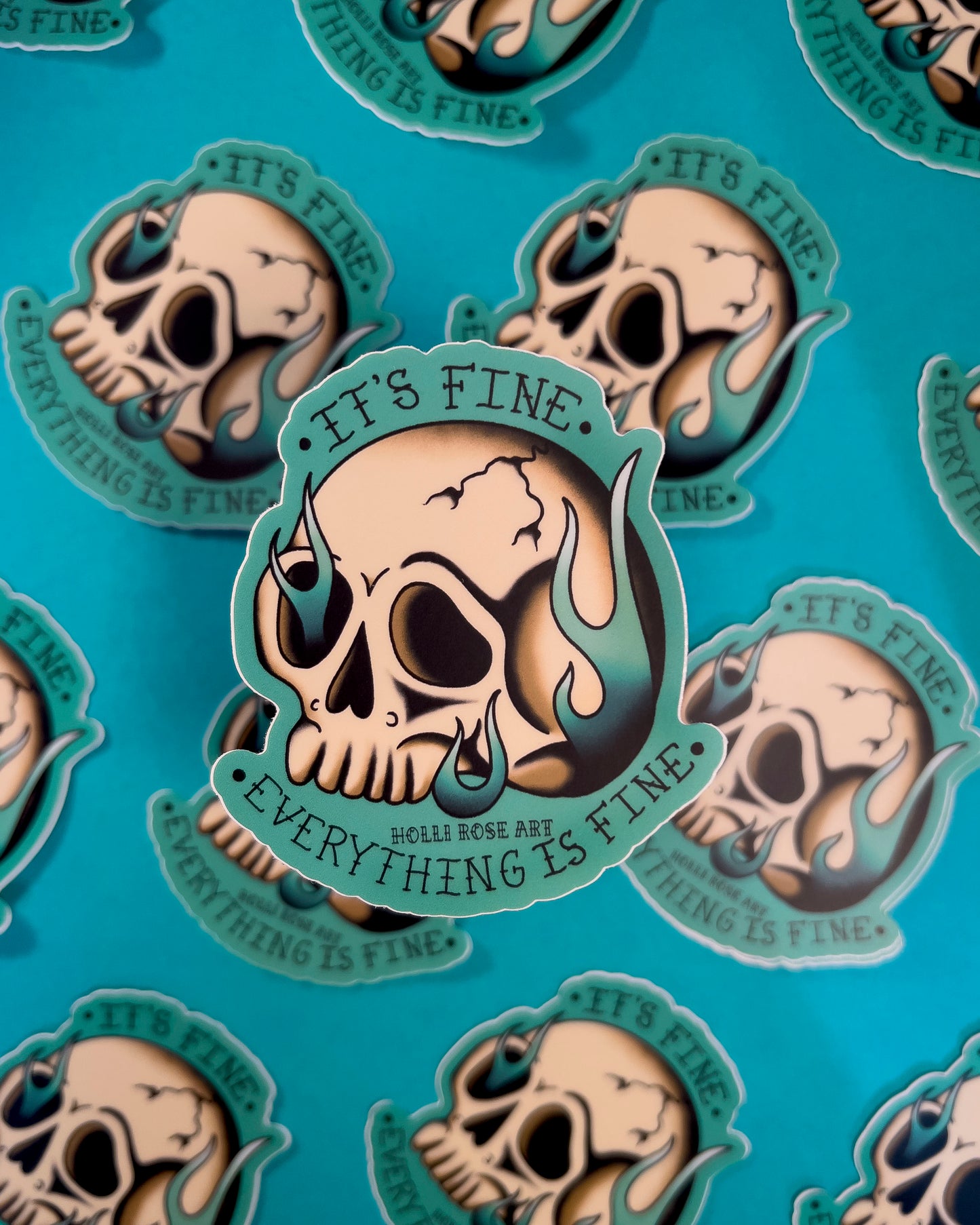 A sticker with a skull on fire saying "it's fine everything is fine"