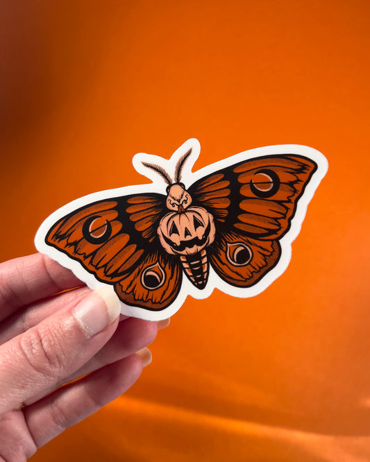 sticker of an orange moth with a pumpkin in the center