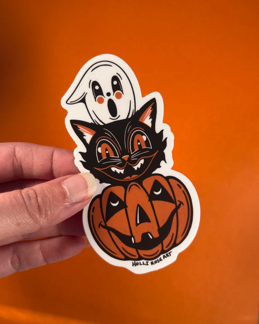 Halloween-themed sticker with a black cat, ghost, and pumpkin on an orange background.