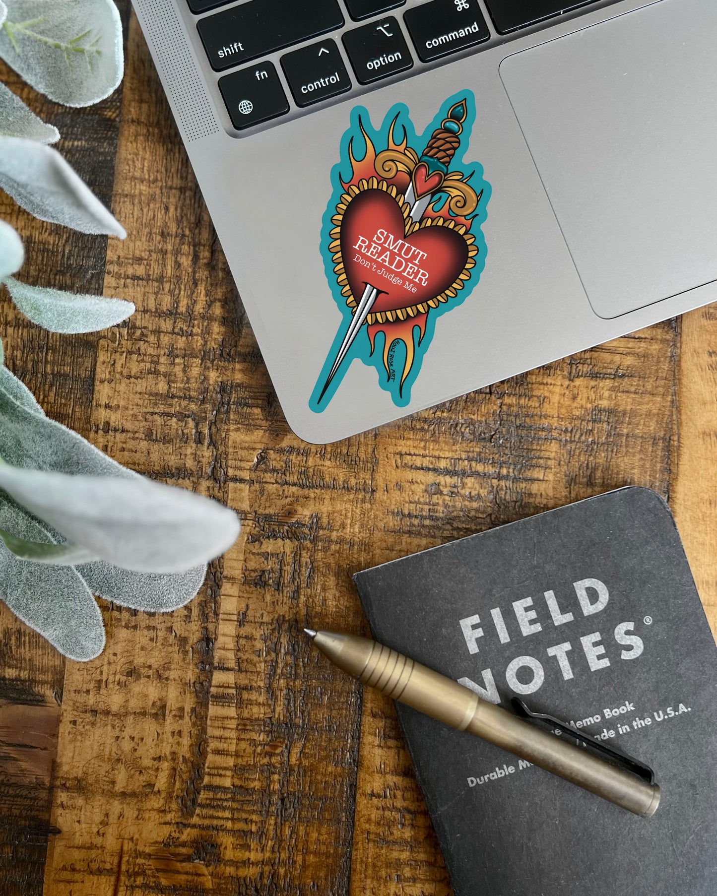 a sticker saying smut with a heart and a dagger