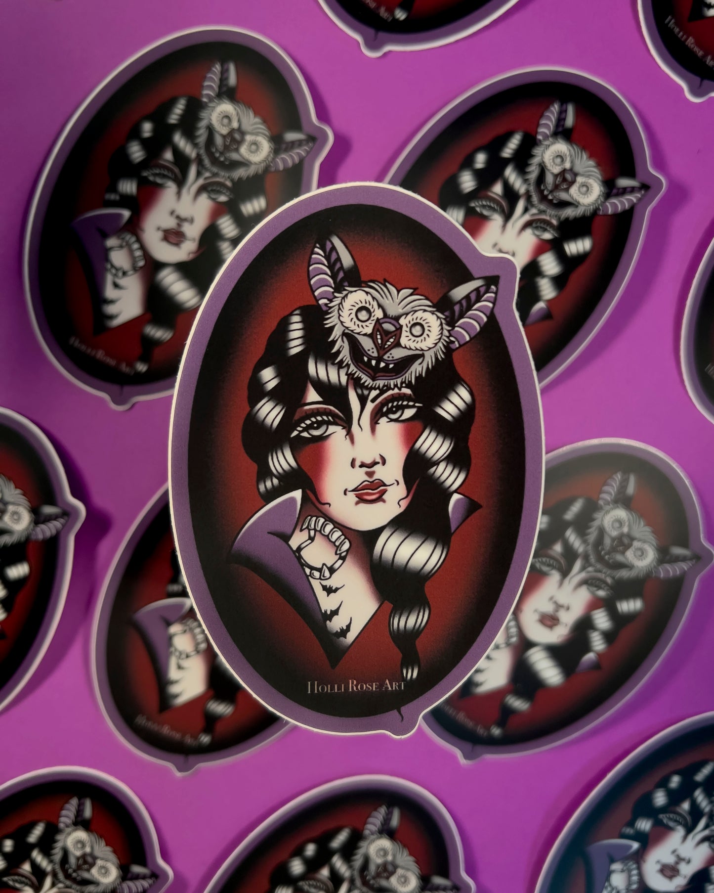 sticker with an American traditional vampire girl and a bat on her head in an oval shape and is purple and red