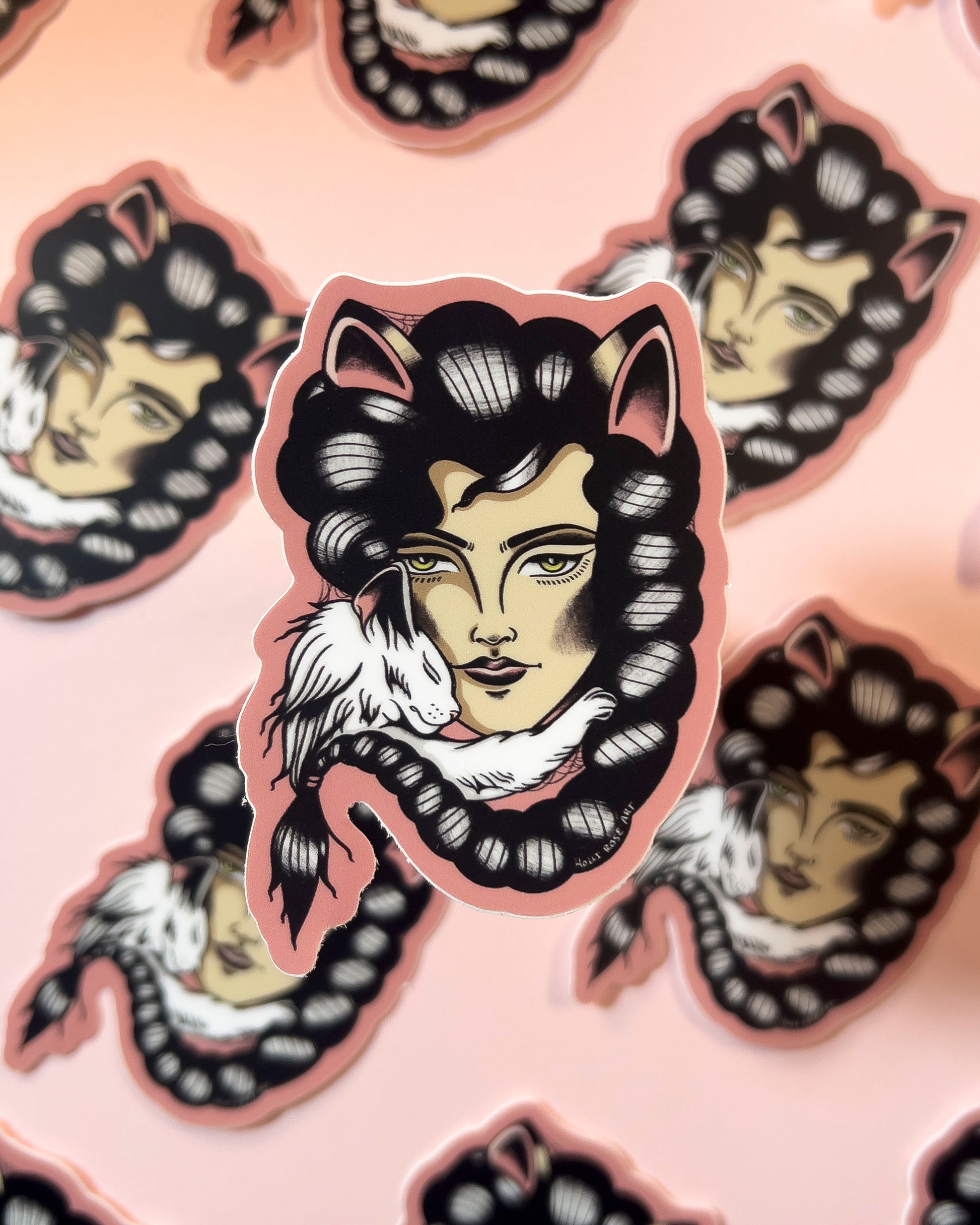 Sticker of a stylized face with cat ears on a pink background
