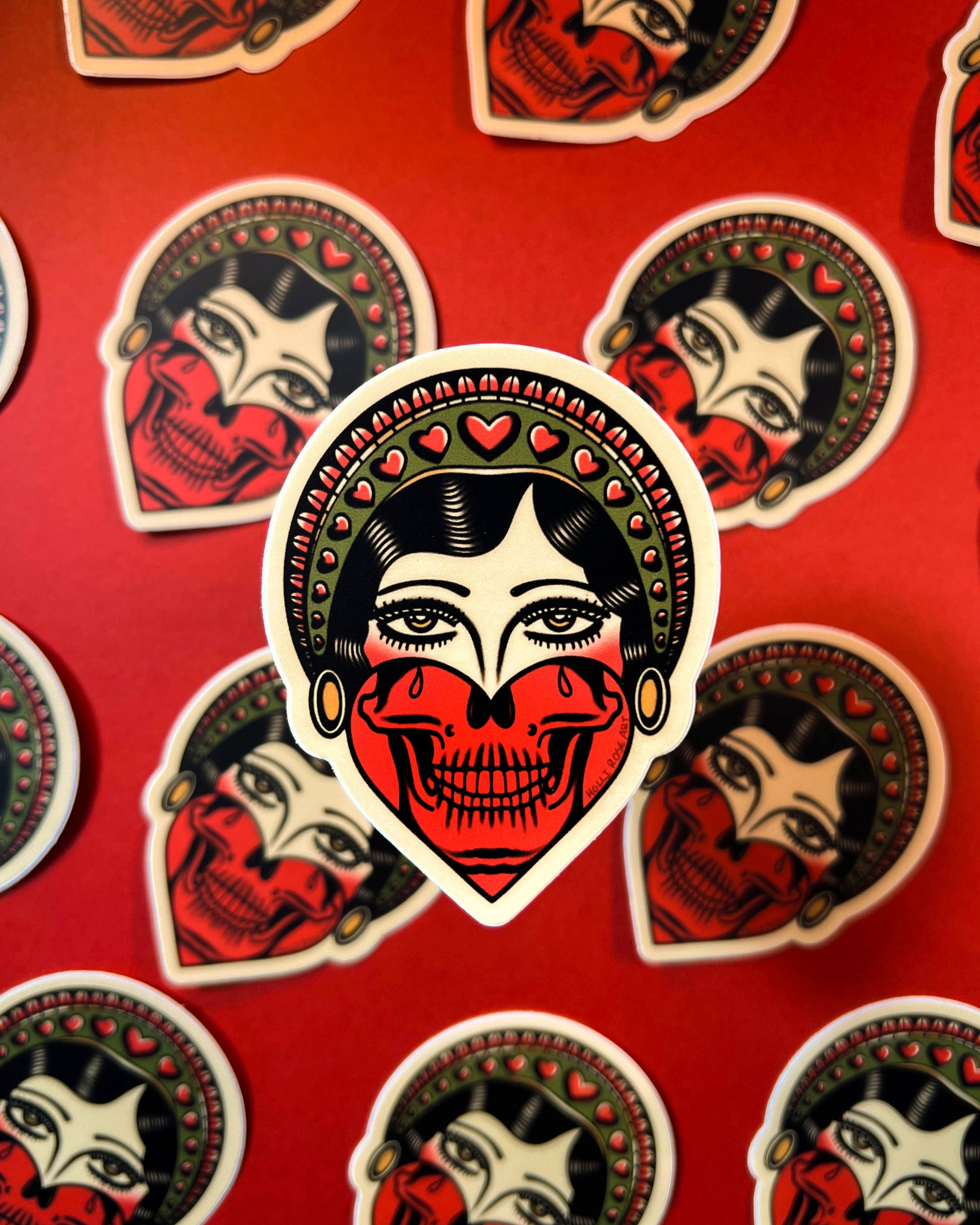 Sticker with a stylized face design on a red background with similar designs.