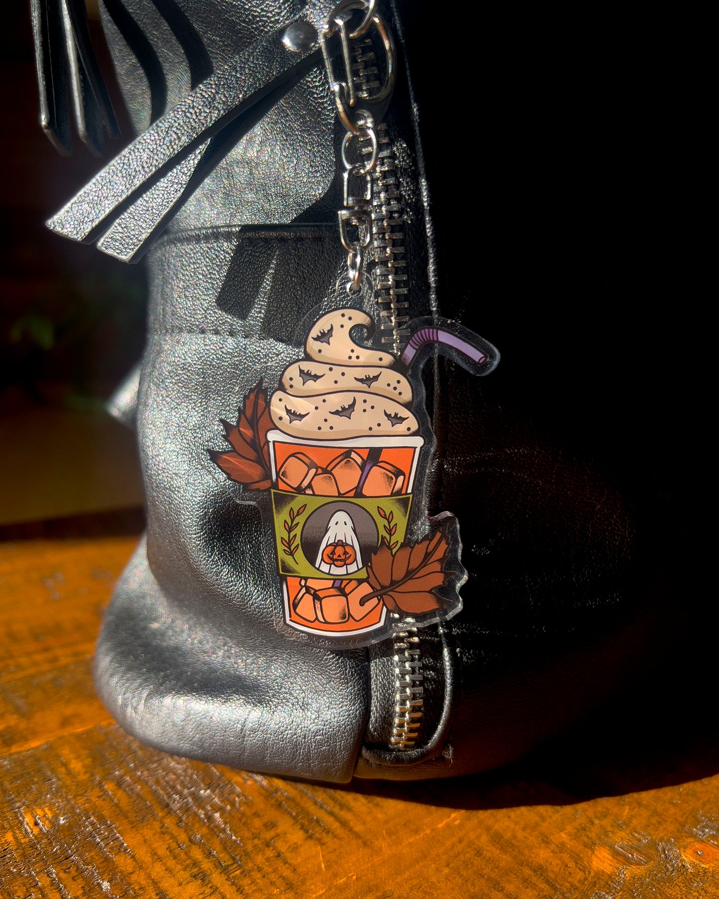 Keychain of an iced pumpkin spiced latte with leaves around it 