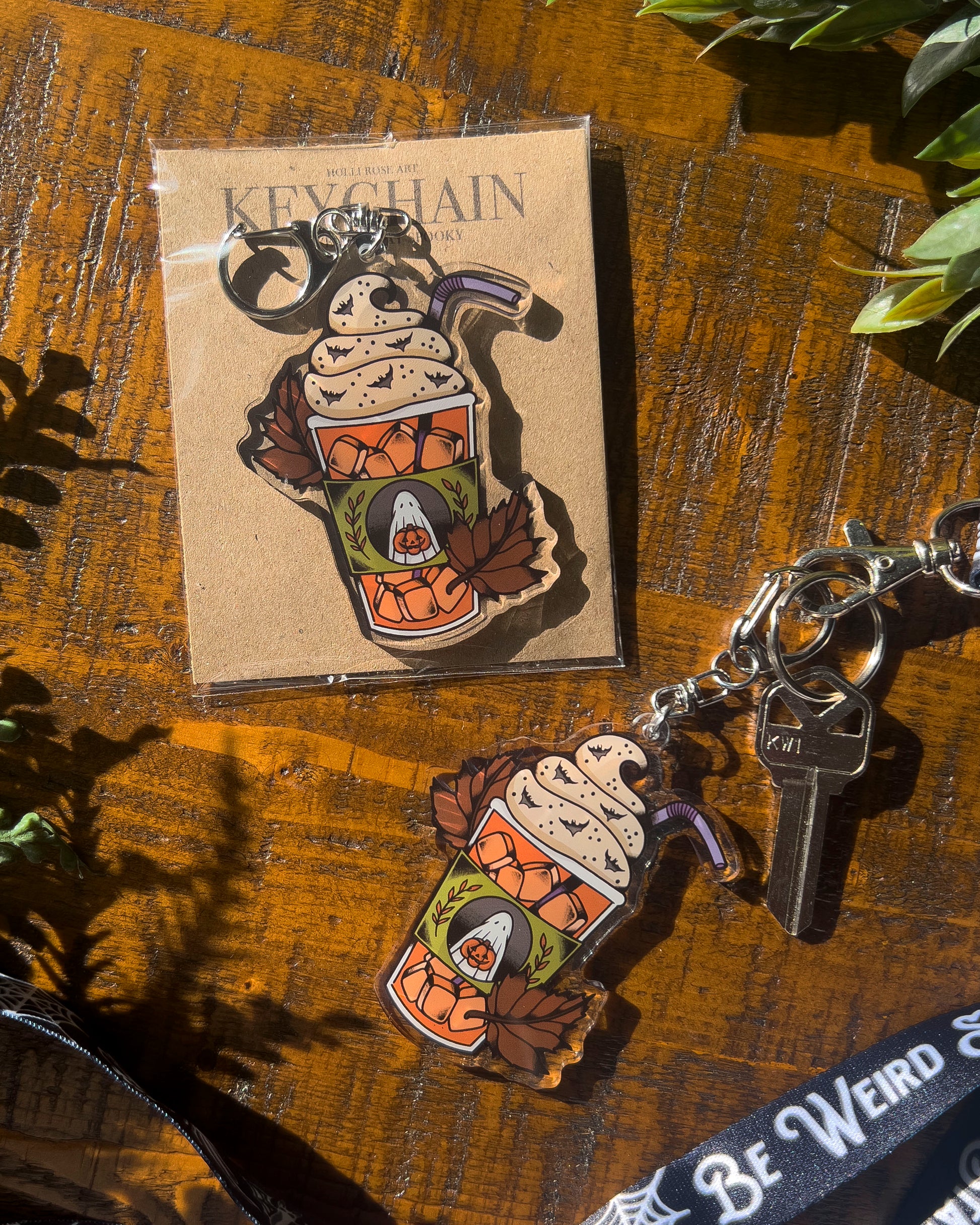 Keychain of an iced pumpkin spiced latte with leaves around it 