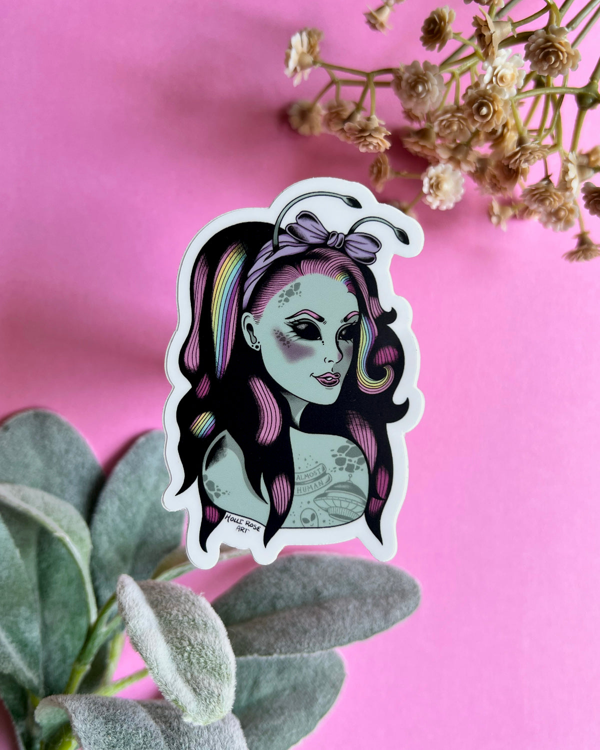 a sticker of an alien girl with rainbow and pink hair and space tattoos