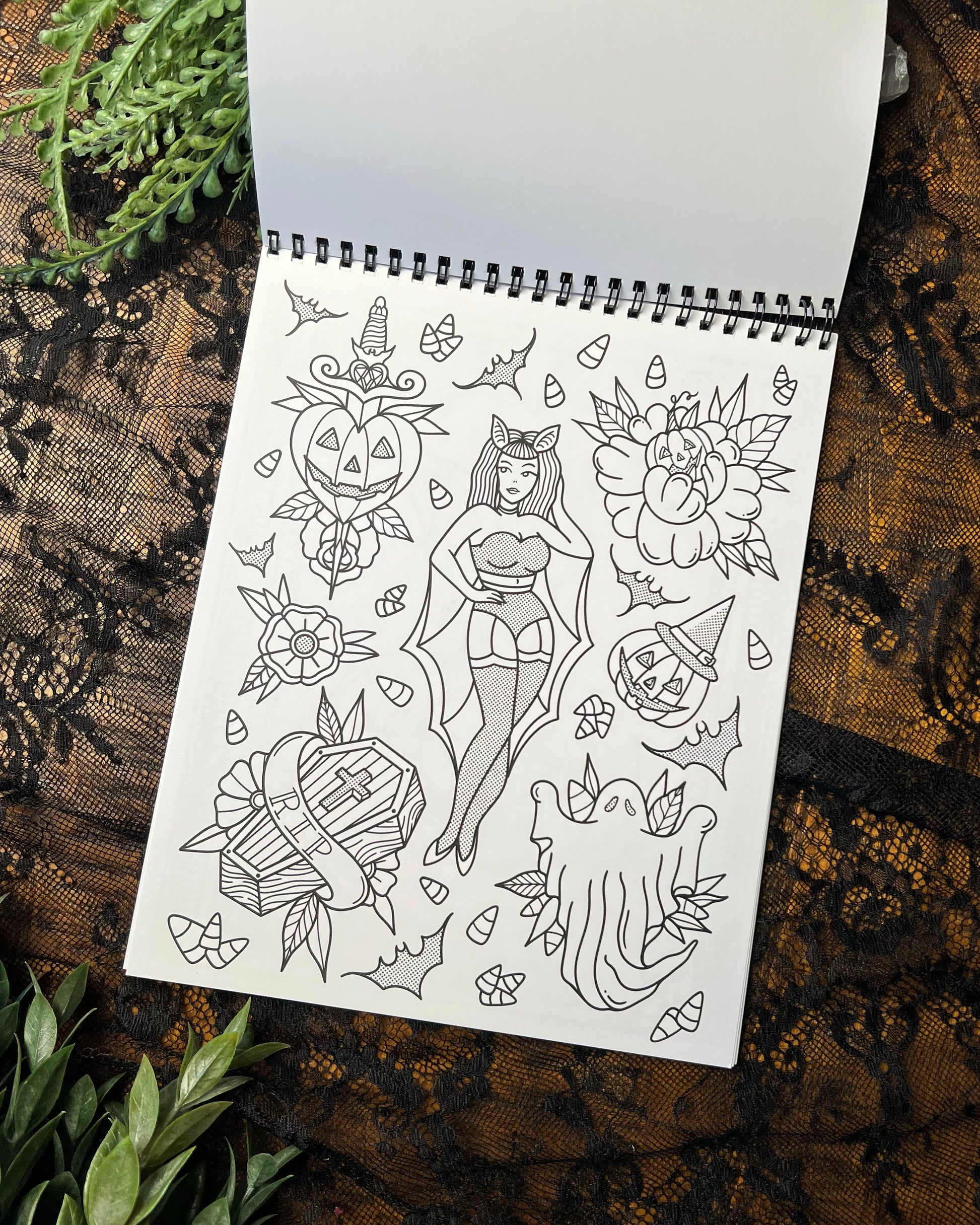 a coloring page with a bat girl, coffin, ghost, and pumpkins