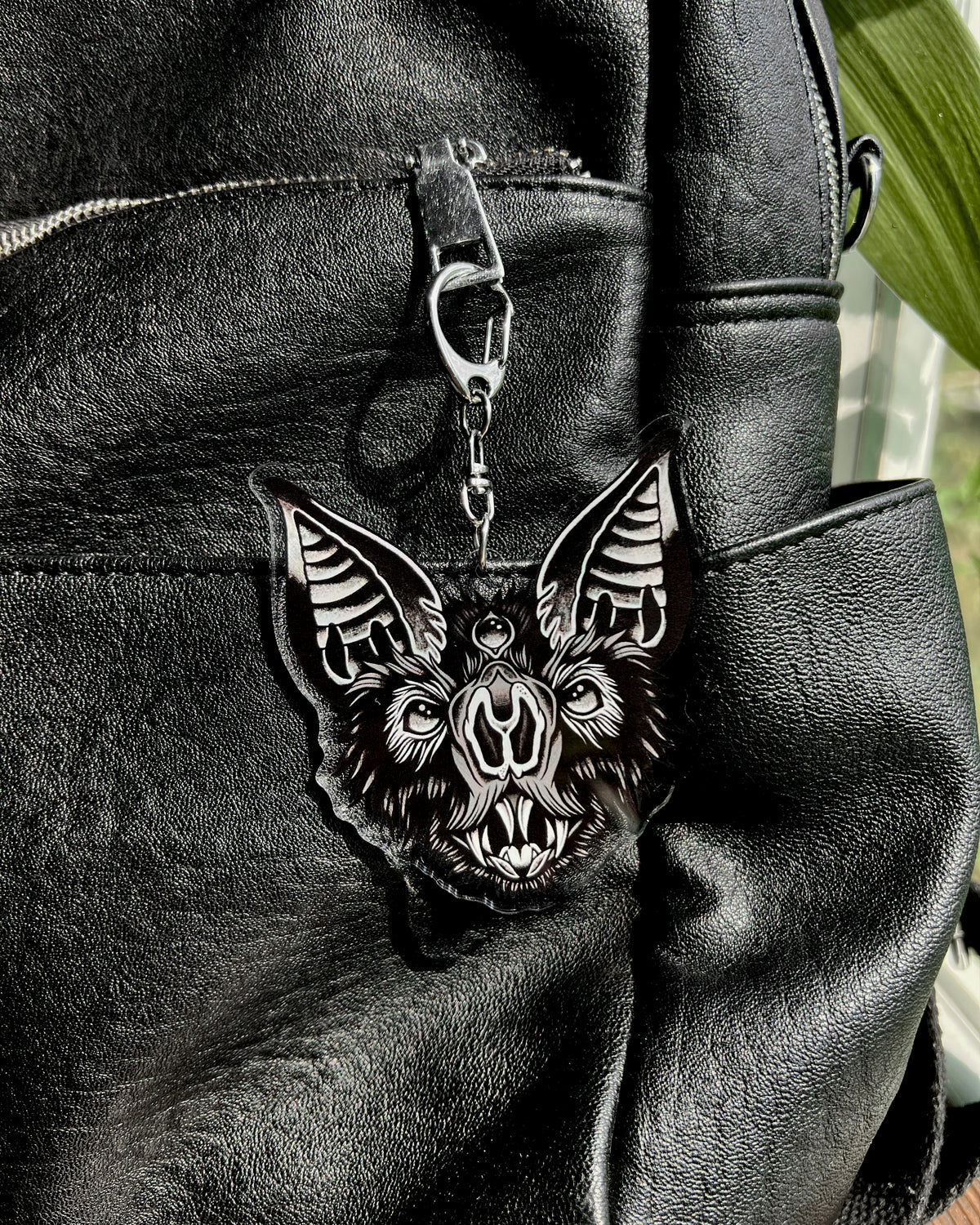 a bat face keychain in black and grey