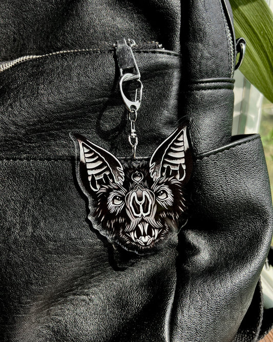 a bat face keychain in black and grey