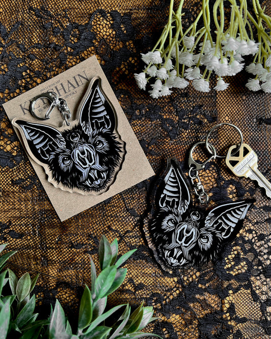 a bat face keychain in black and grey