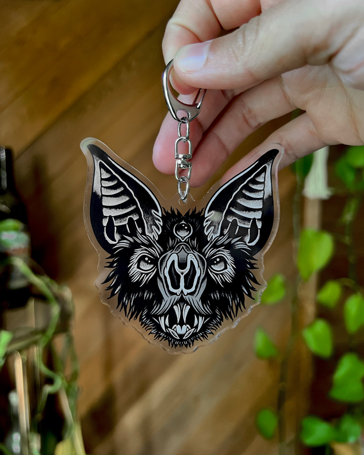 a bat face keychain in black and grey