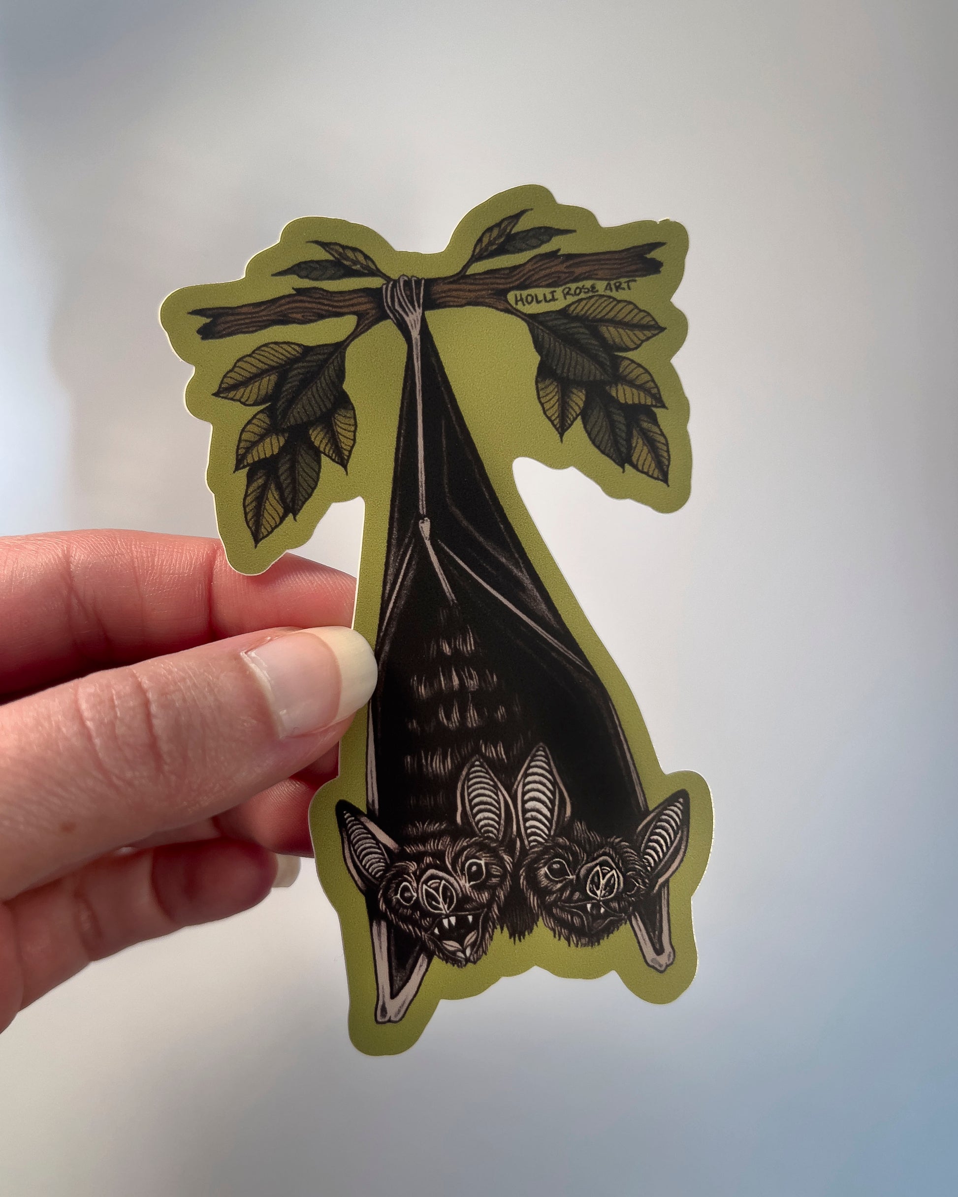 double headed bat hanging upside down from a tree branch sticker