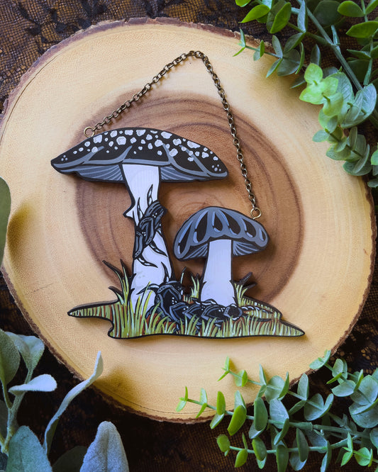 hand painted mushroom hanging with black mushrooms and a centipede 