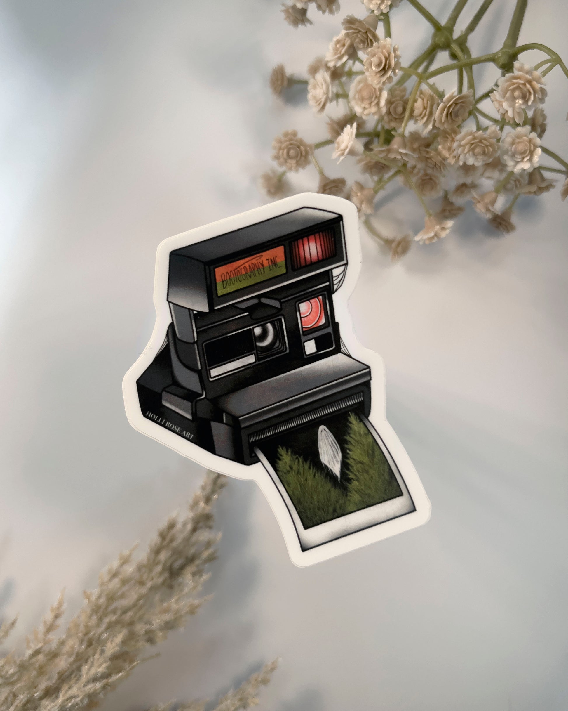 old style camera with the saying "bootography" on it and a polaroid coming  out of it with a picture of a ghost