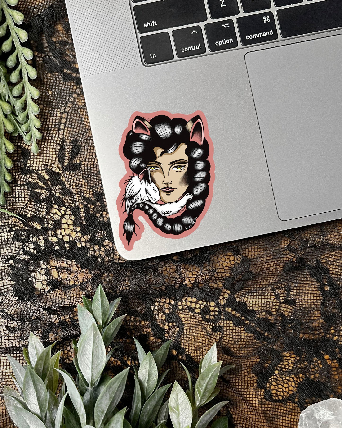 Sticker of a woman with cat ears on a laptop with a lace background