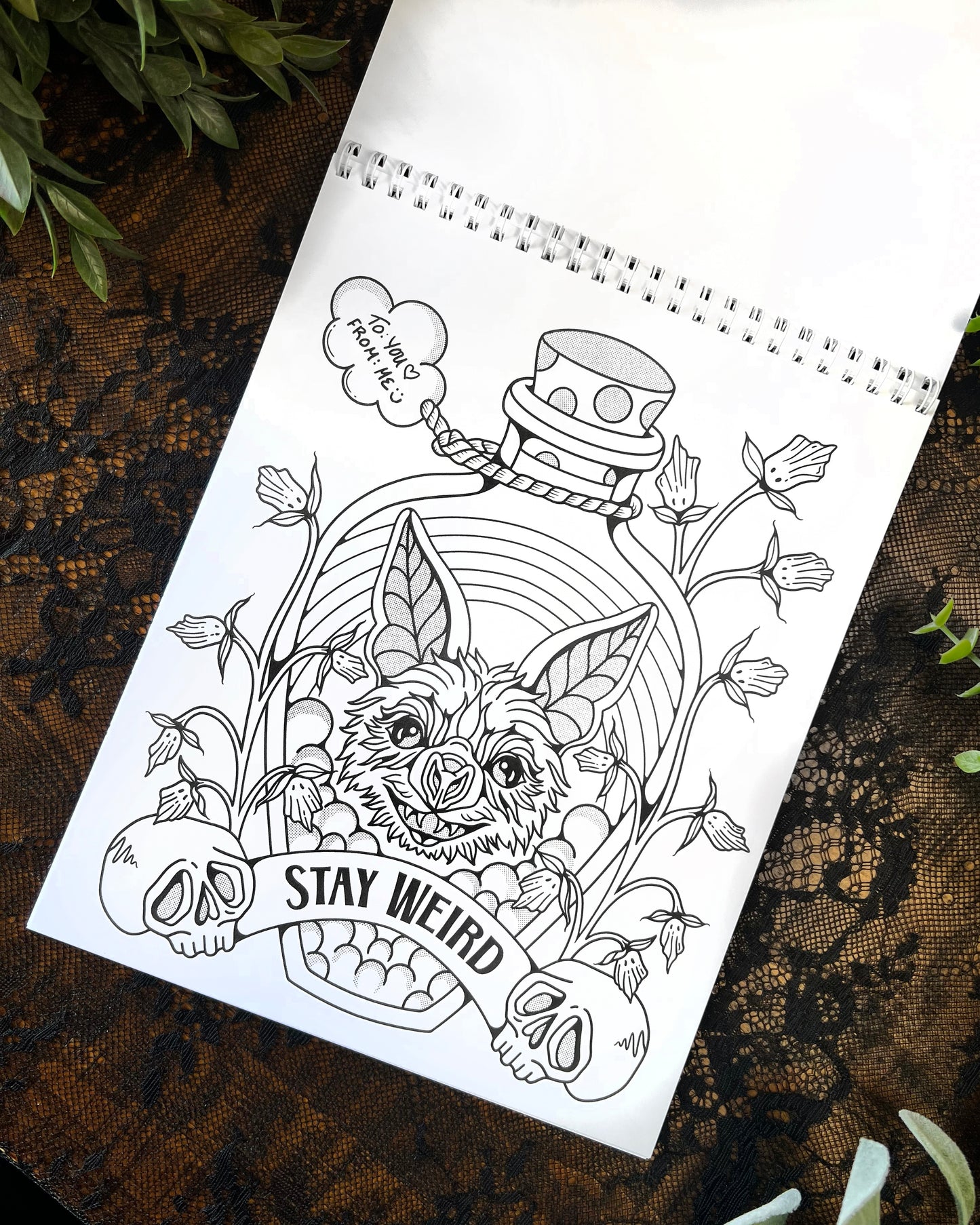 coloring page with a bat head and rainbow in a bottle with the words "stay weird"