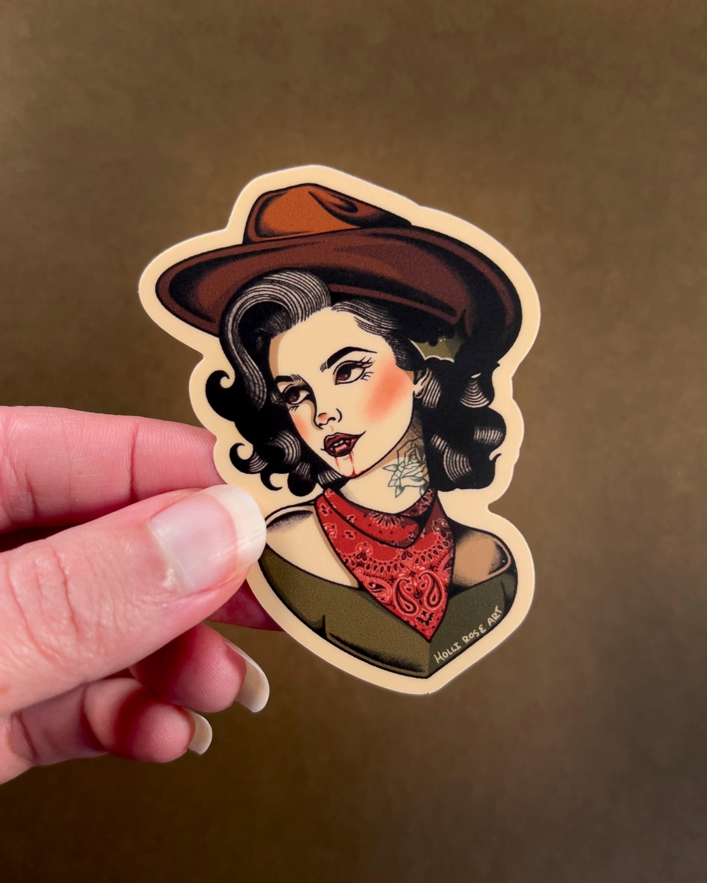sticker of a woman in a cowboy hat, with vampire teeth and blood running down her chin