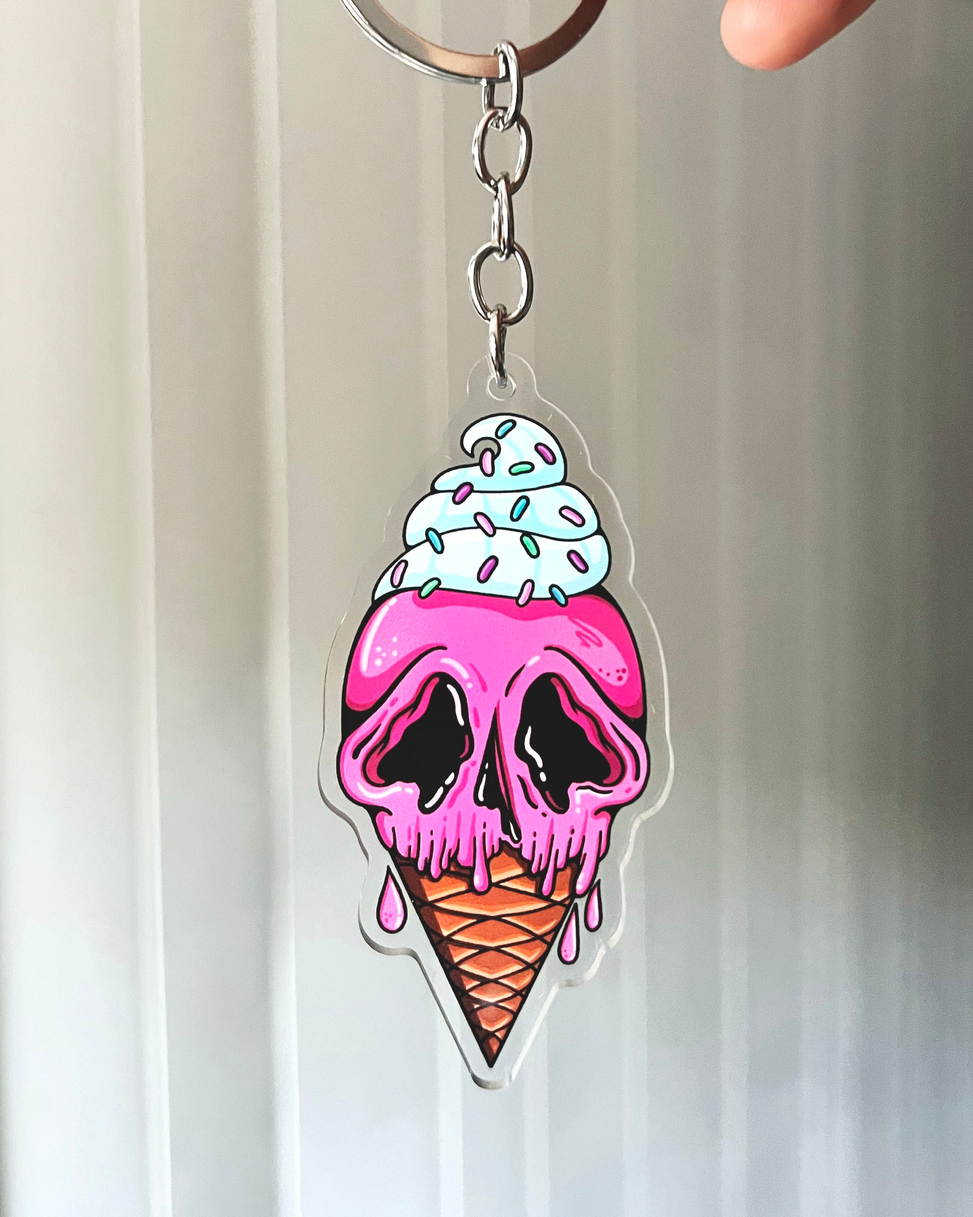 Keychain with a skull design in an ice cream cone, pink and white colors.