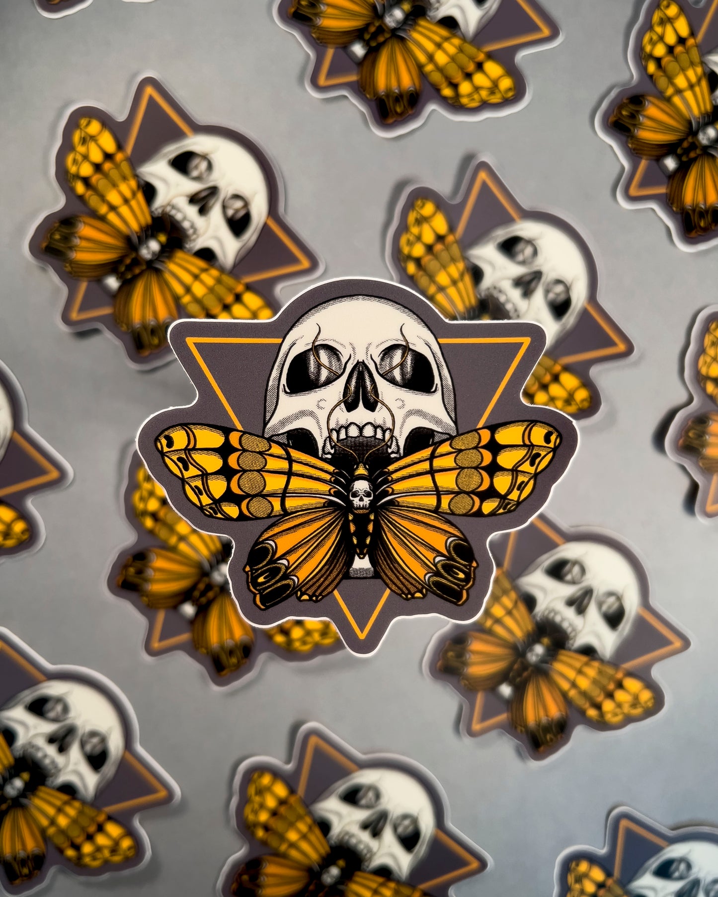Pattern of butterfly and skull designs on a gray background