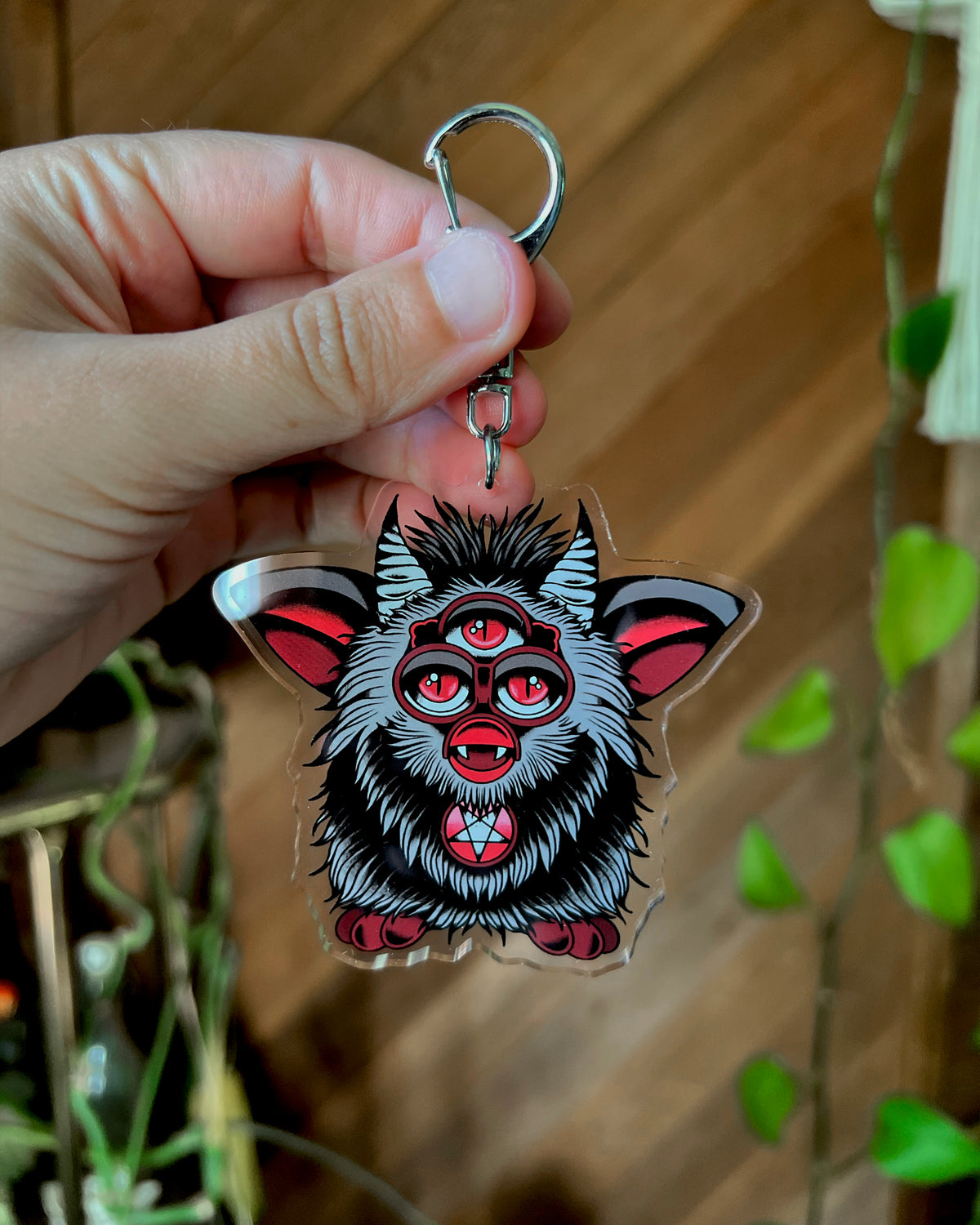 a three eyed evil furb keychain in black and red 
