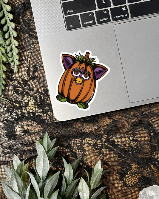 Pumpkin sticker with animal features on a laptop