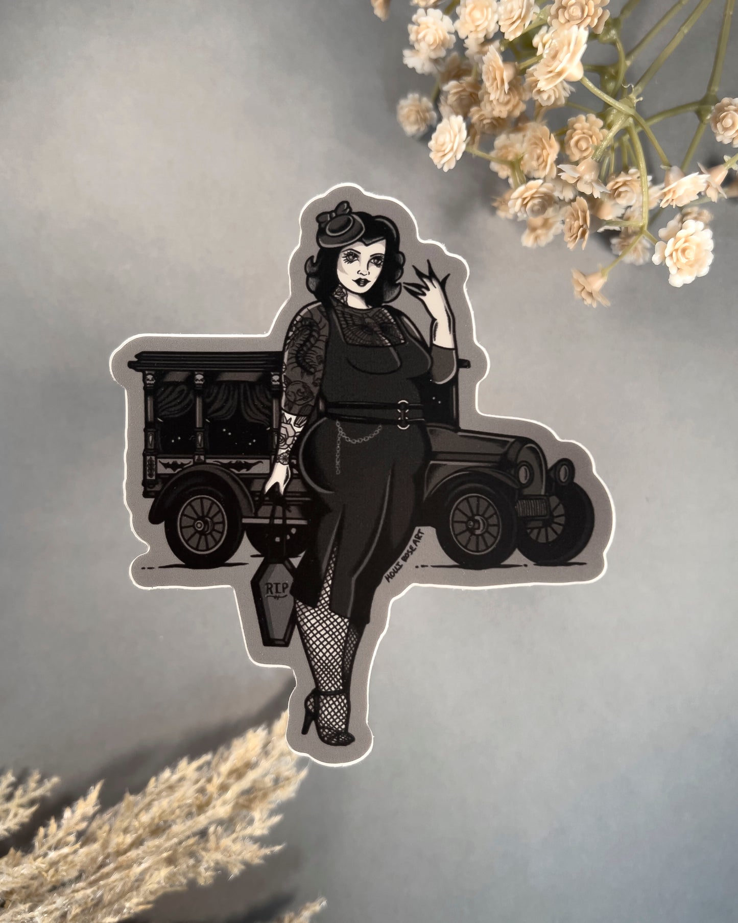 Goth girl sticker wearing a black dress with a black old vehicle behind her