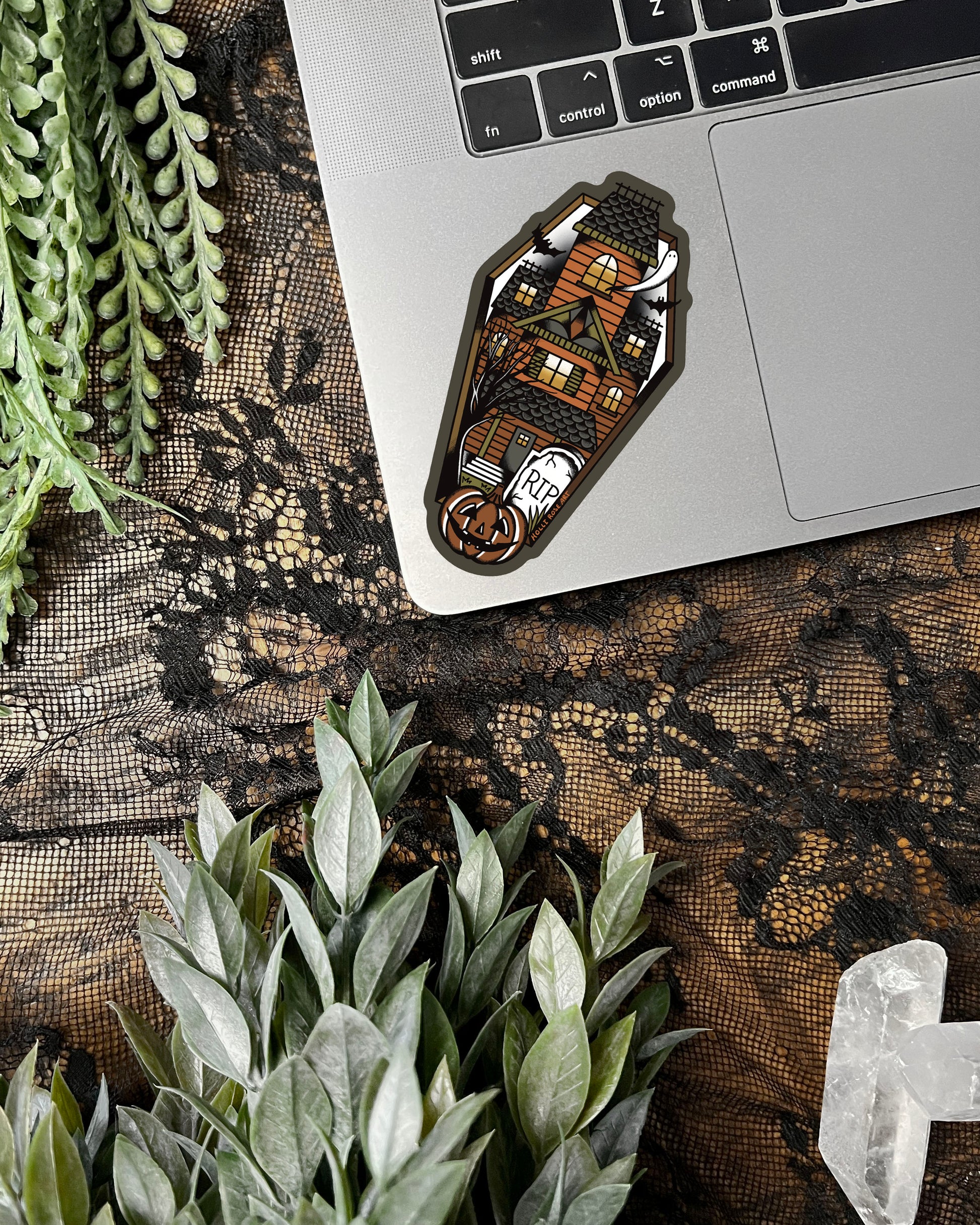 sticker shaped like a coffin with a haunted house inside