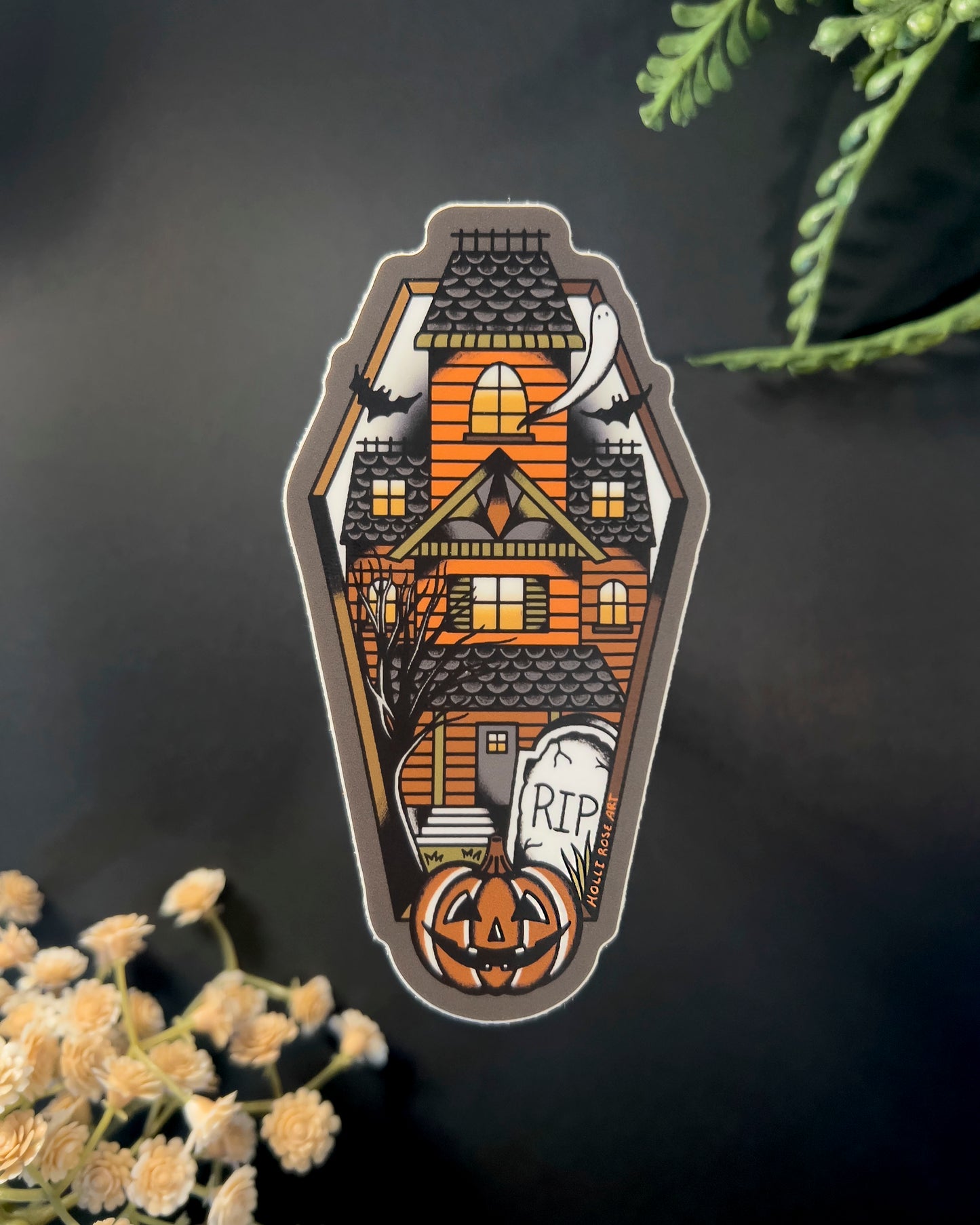 sticker shaped like a coffin with a haunted house inside