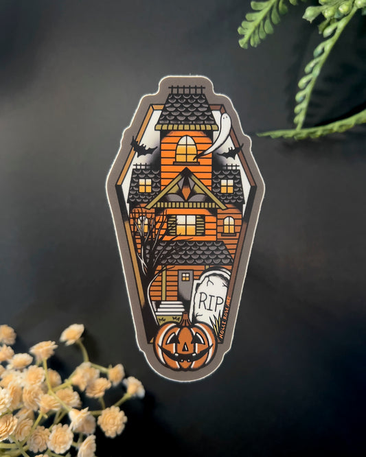 sticker shaped like a coffin with a haunted house inside
