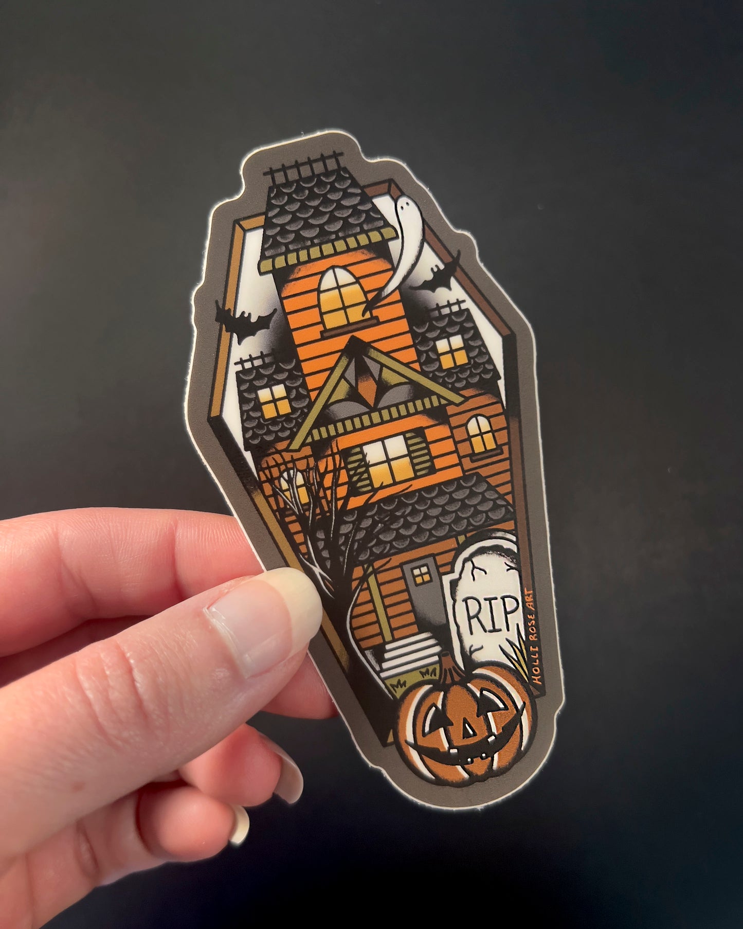 sticker shaped like a coffin with a haunted house inside