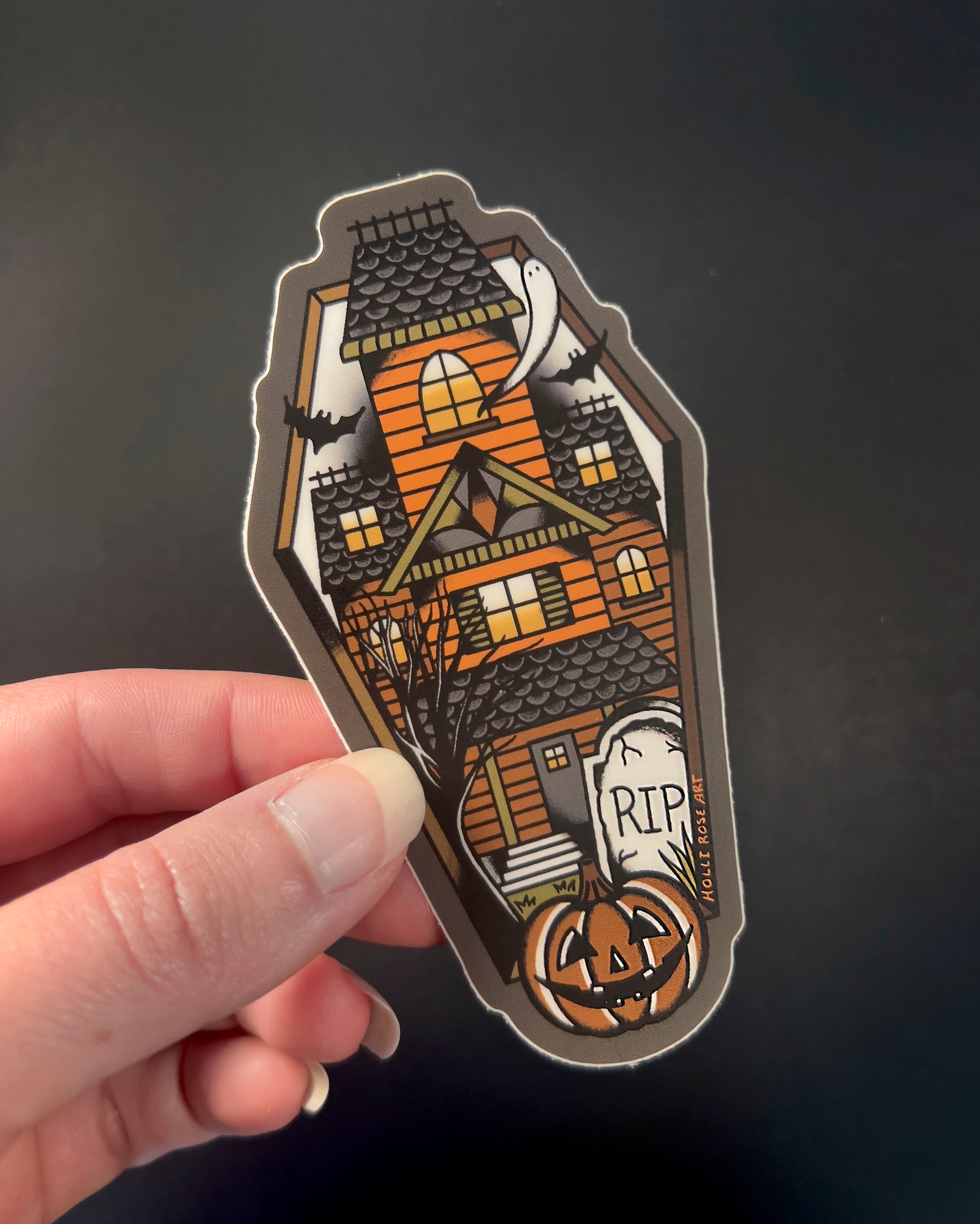 sticker shaped like a coffin with a haunted house inside
