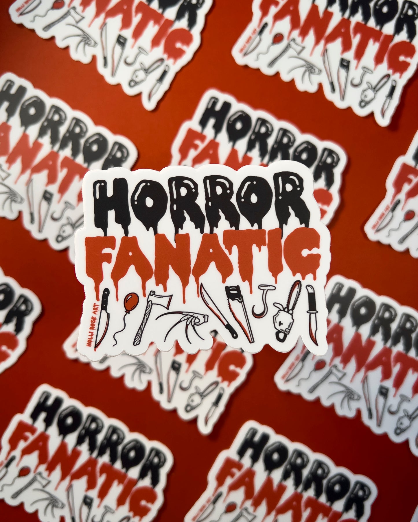 a sticker that says "horror fanatic" with various weapons on the bottom