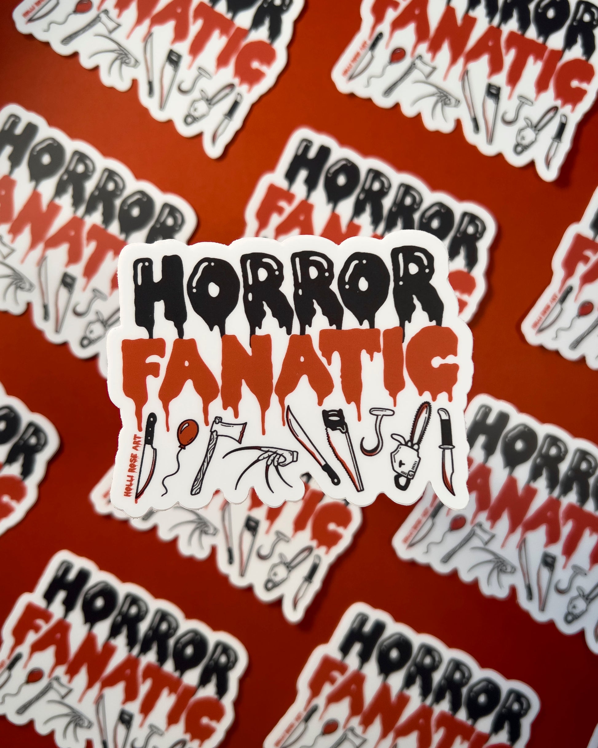a sticker that says "horror fanatic" with various weapons on the bottom