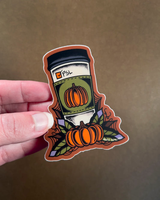 Sticker of a pumpkin spice latte with pumpkins held by a hand on a brown background
