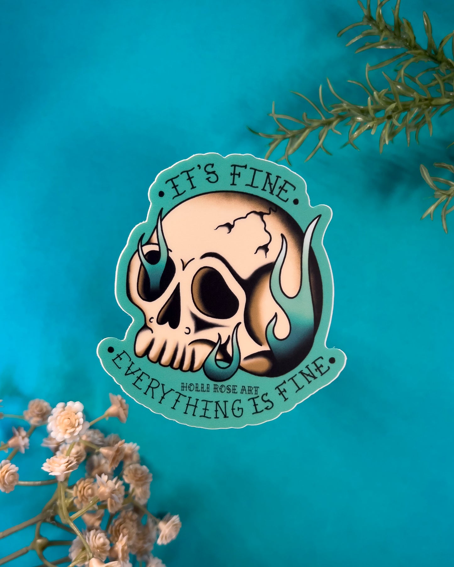 A sticker with a skull on fire saying "it's fine everything is fine"