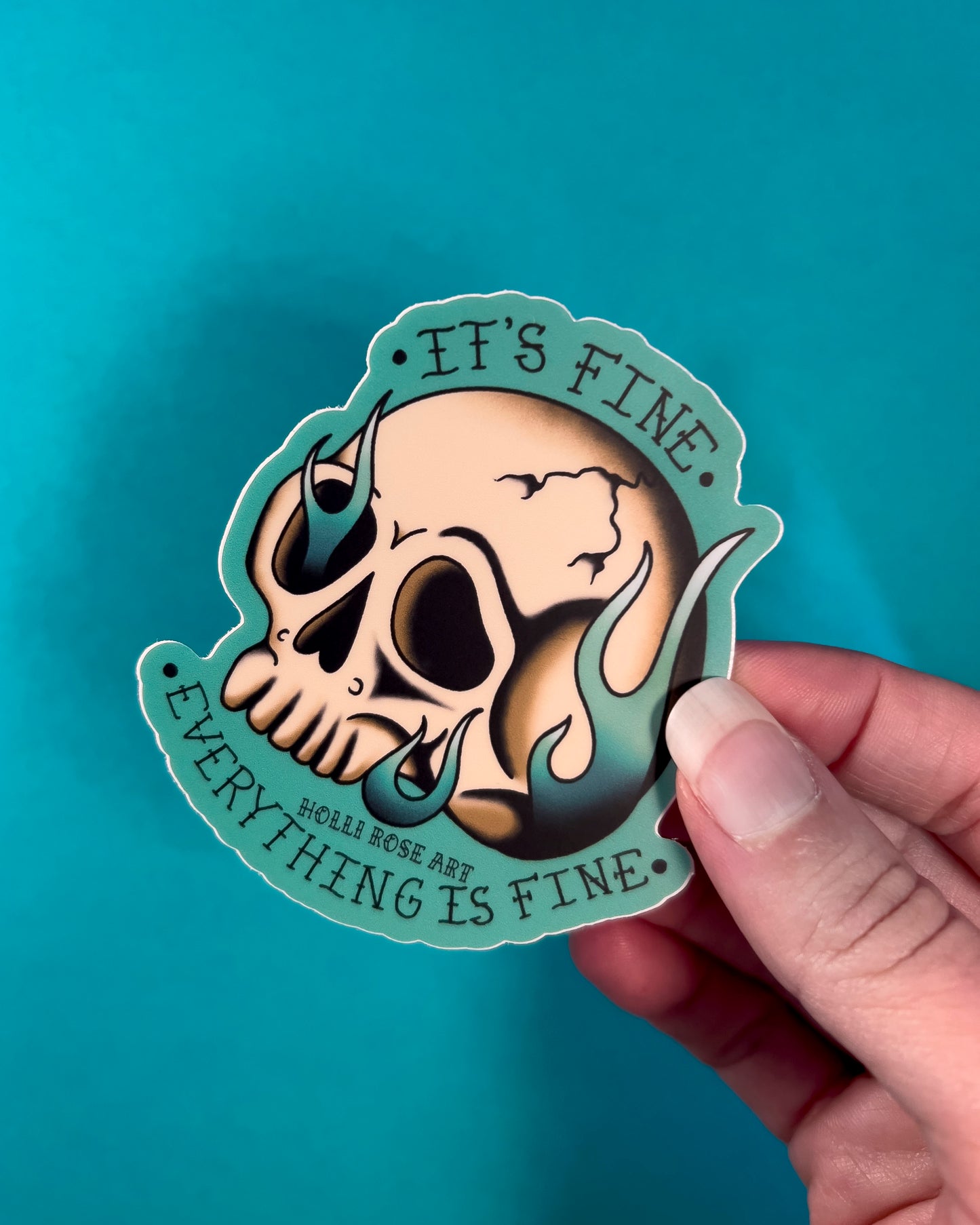 A sticker with a skull on fire saying "it's fine everything is fine"