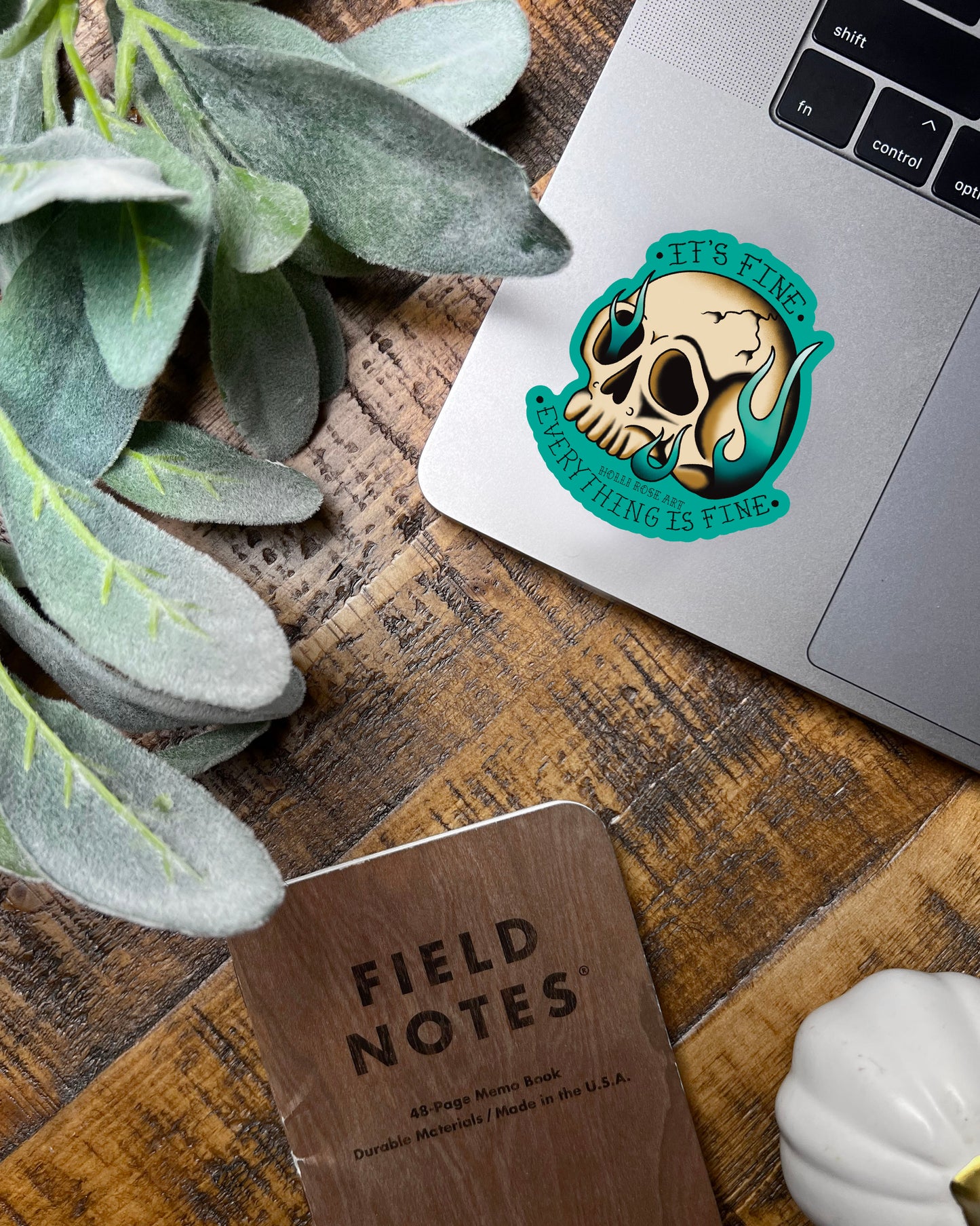 A sticker with a skull on fire saying "it's fine everything is fine"