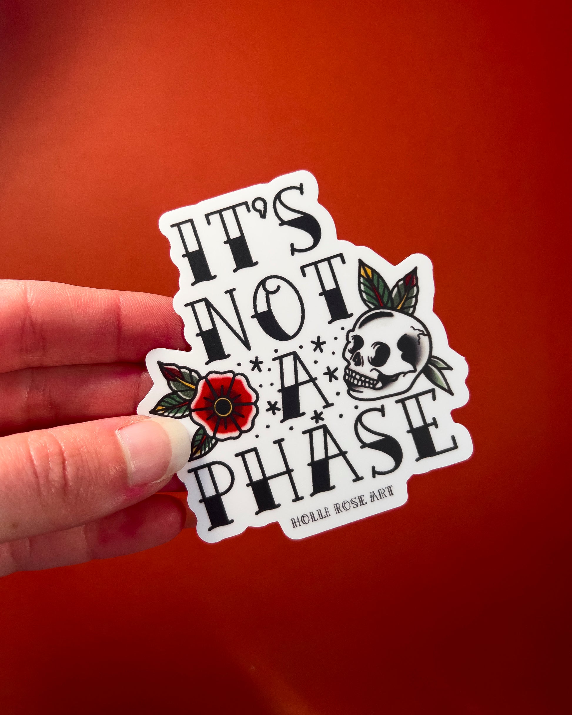 a sticker with a flower and a skull that says "its not a phase"