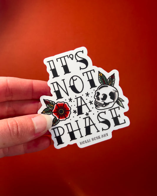 a sticker with a flower and a skull that says "its not a phase"