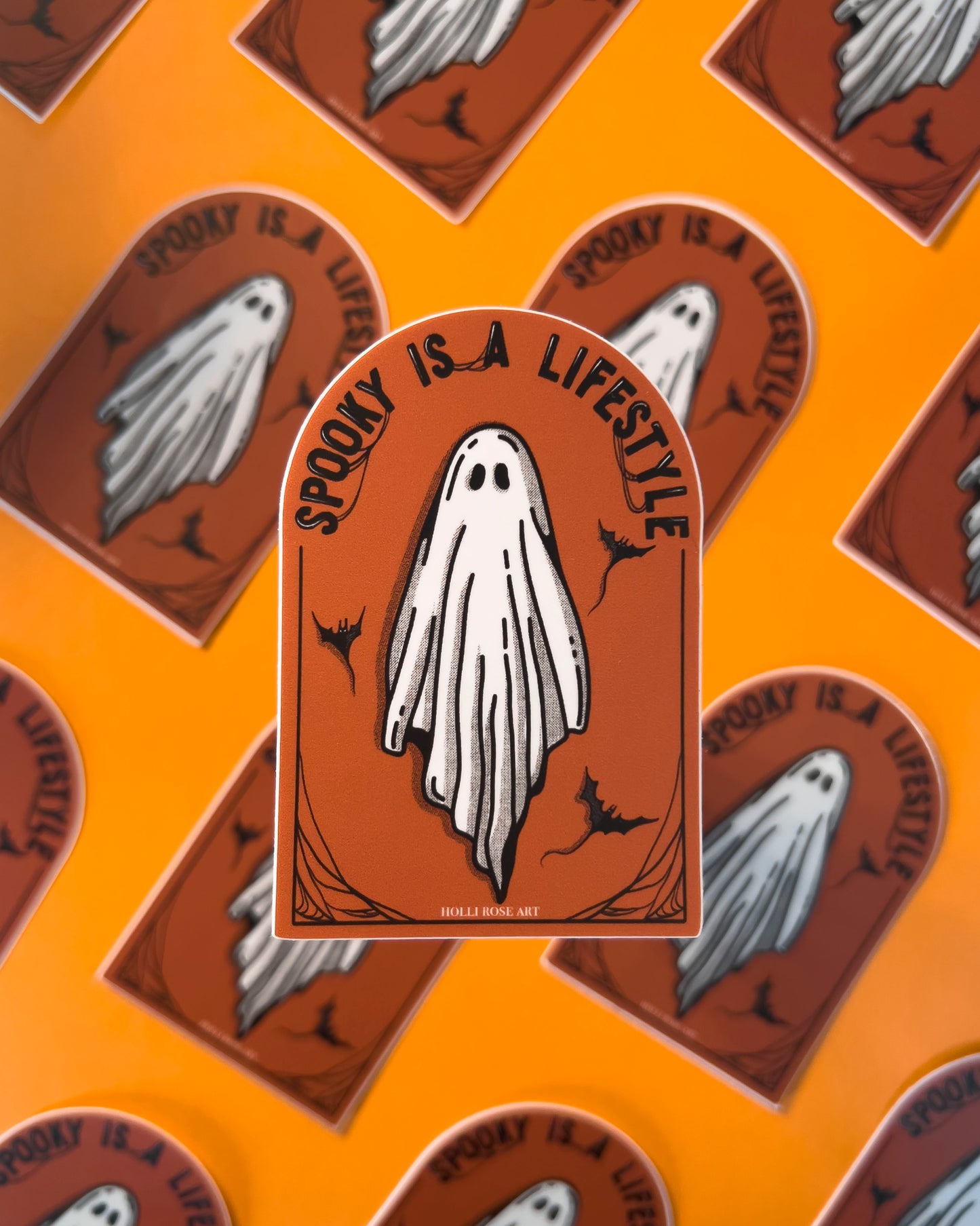 orange sticker with a ghost and the saying "spooky is a lifestyle" sticker