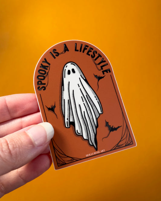 orange sticker with a ghost and the saying "spooky is a lifestyle" sticker