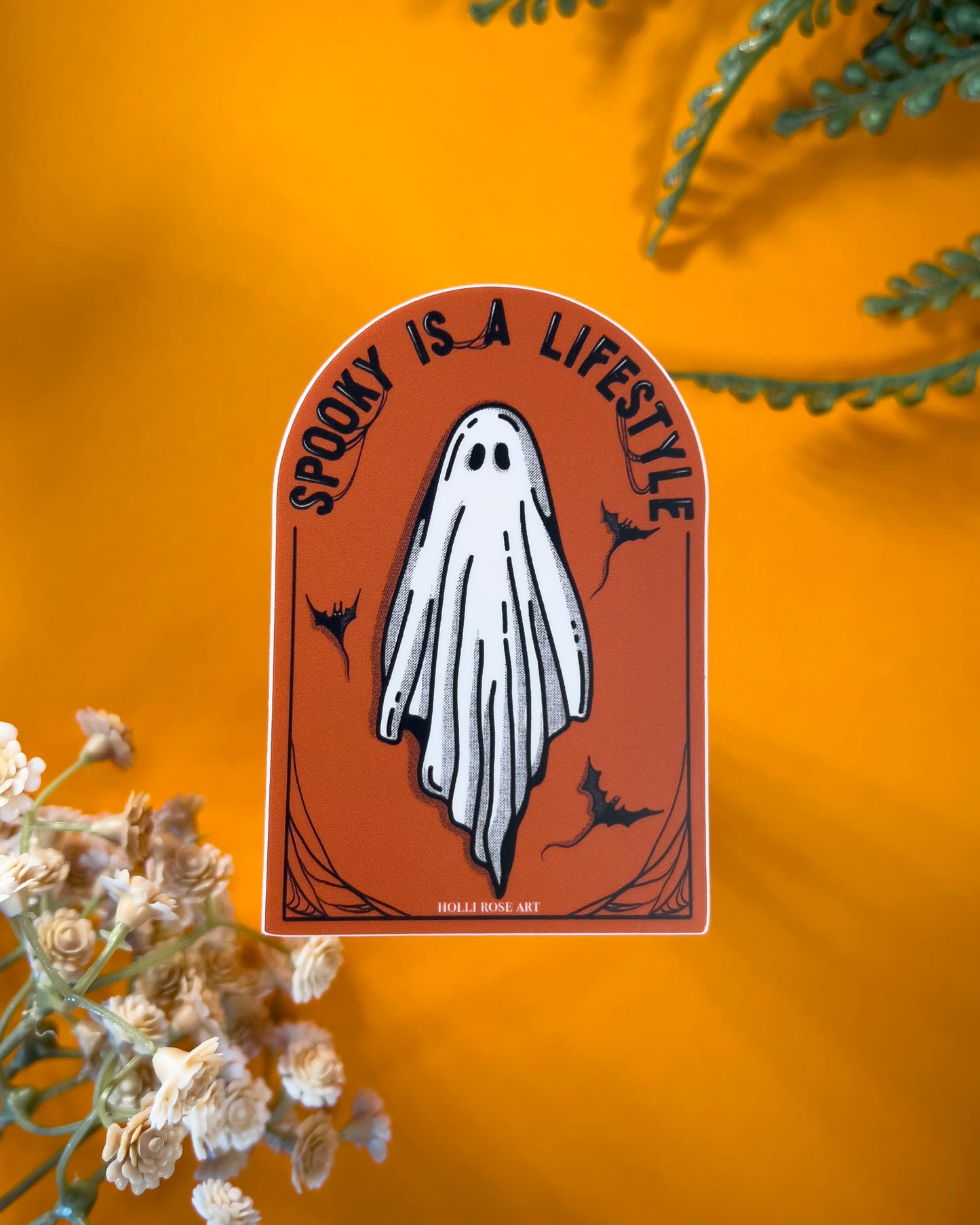 orange sticker with a ghost and the saying "spooky is a lifestyle" sticker