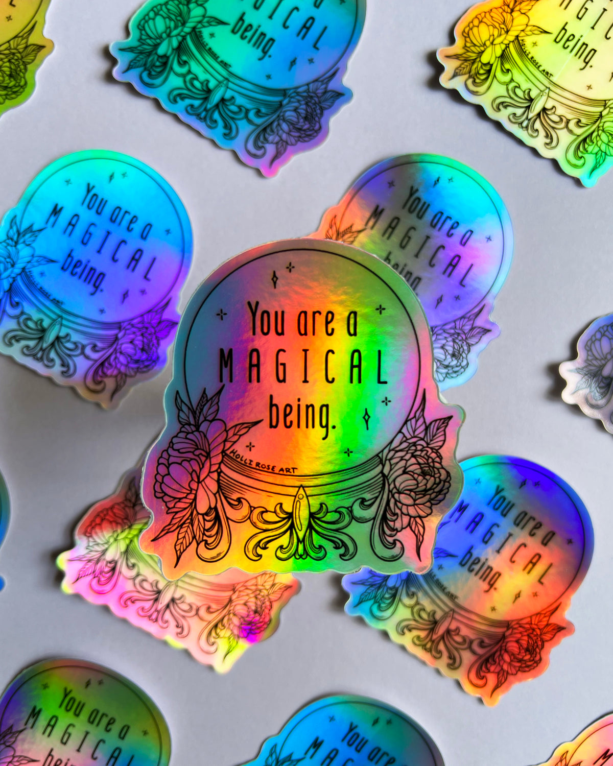 a colorful holographic sticker saying you are a magical being in a witch ball