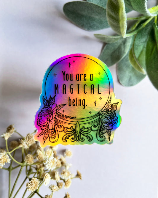 a colorful holographic sticker saying you are a magical being in a witch ball