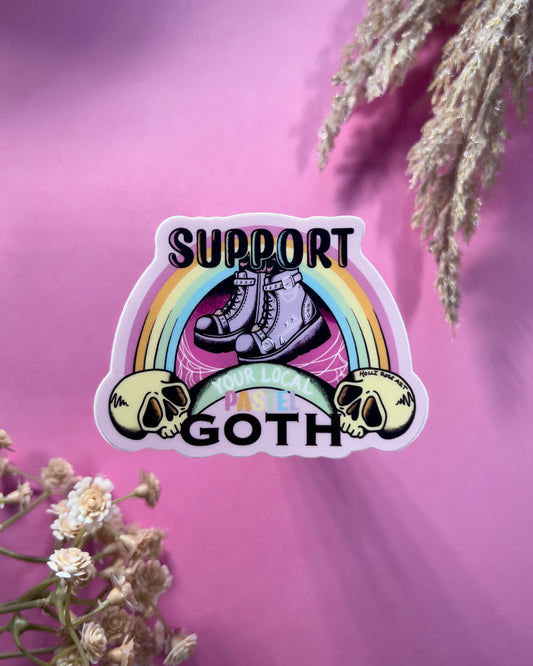 a sticker that says support your local pastel goth with purple goth boots, a rainbow and a skull