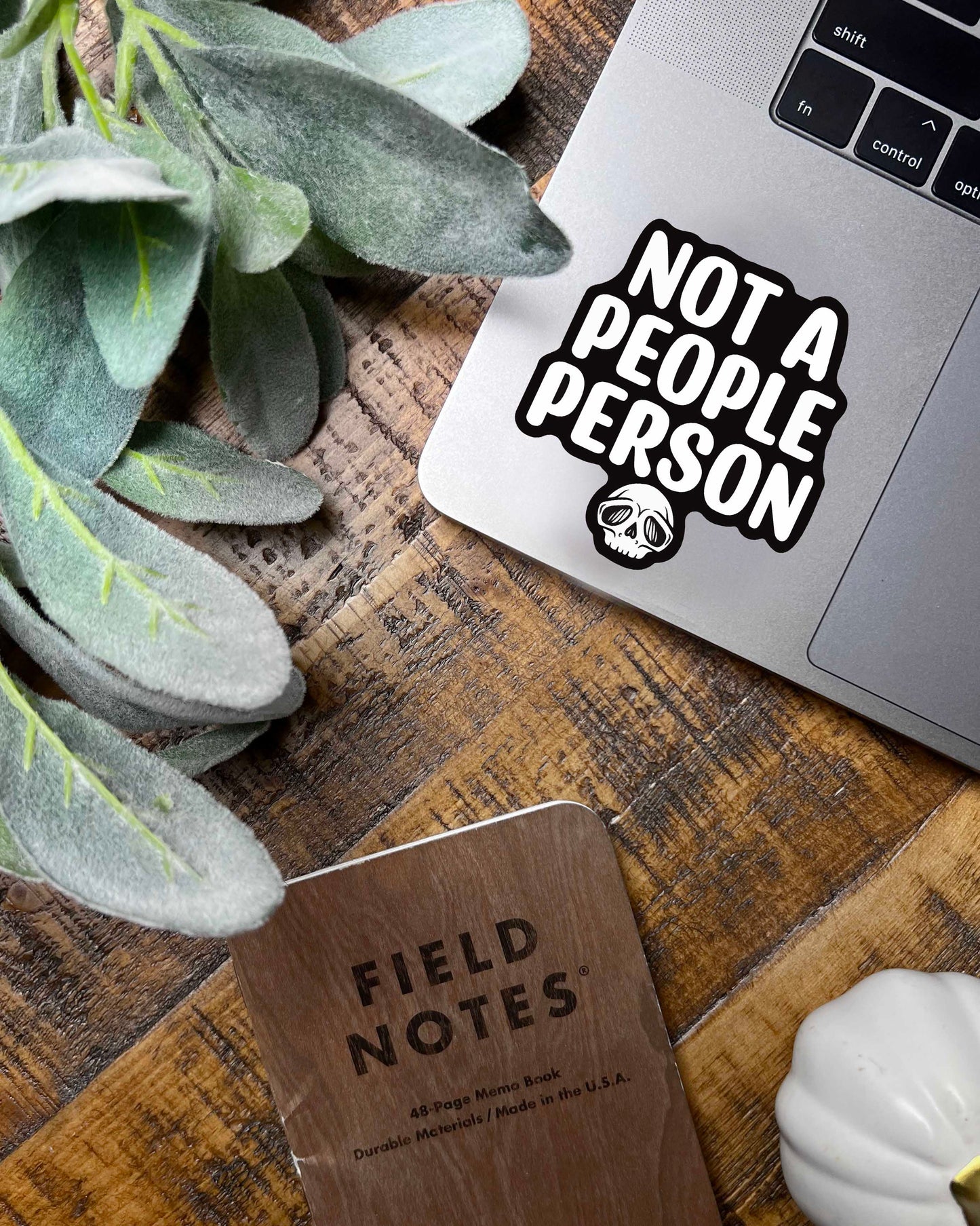 sticker with words saying "not a people person" on a laptop
